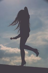 Silhouette woman standing against sky during sunset