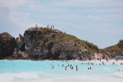 People swimming in pool against sky