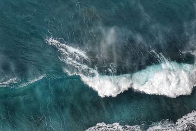 High angle view of waves splashing on sea