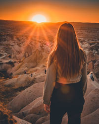 Rear view of woman looking at sunset