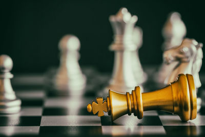 Close-up of chess pieces on board against black background