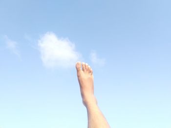 Low section of person against blue sky