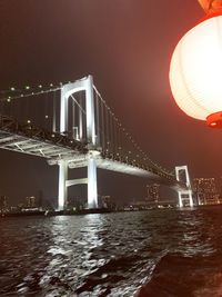 View of bridge over river at night