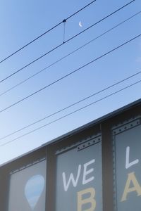 Low angle view of power lines against clear sky