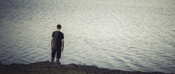 Rear view of man standing on beach