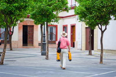 Full length of woman standing by tree