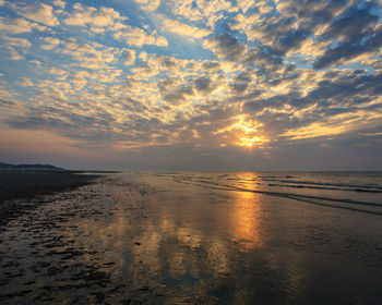 Scenic view of beach against sky during sunset