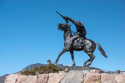 Low angle view of statue against clear blue sky