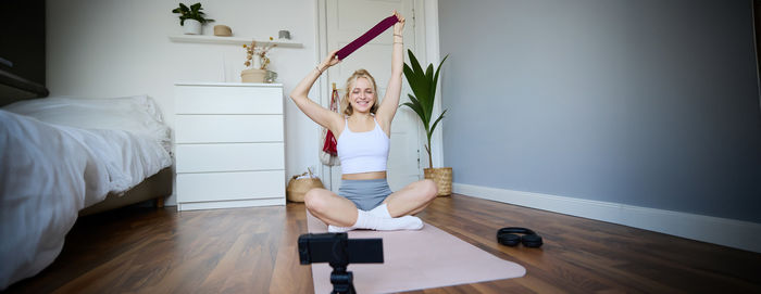 Rear view of woman doing yoga at home