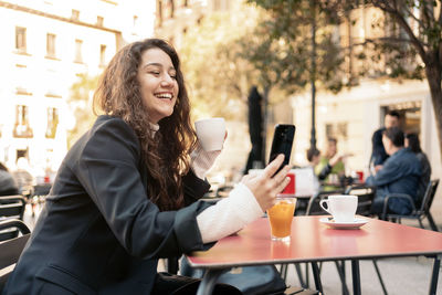 Young woman using mobile phone in cafe