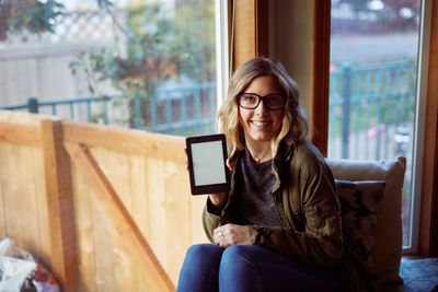 Portrait of smiling young woman using mobile phone