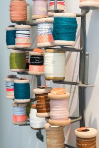 Close-up of colorful spools on rack