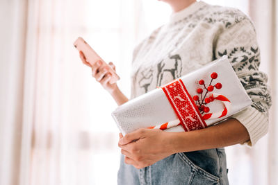 Midsection of man holding book at home