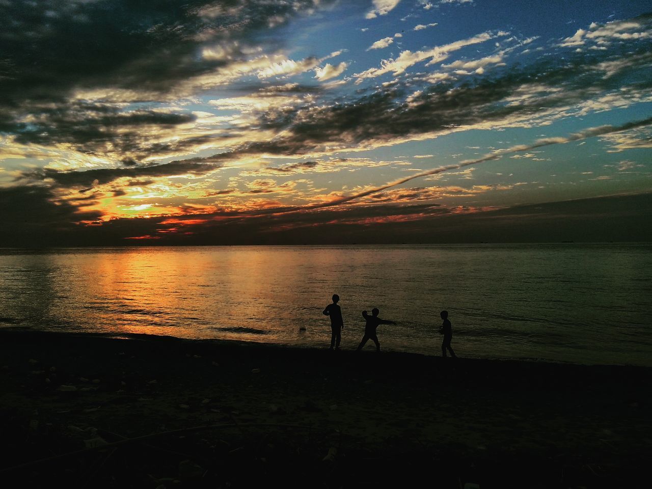 SILHOUETTE PEOPLE STANDING AT SEA AGAINST SKY DURING SUNSET