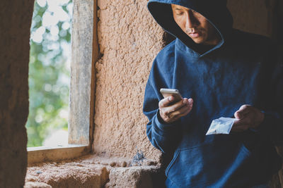 Midsection of man using mobile phone