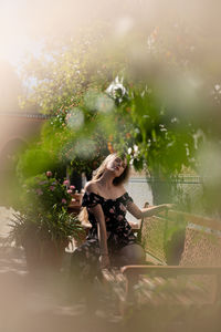 Woman sitting on flowering plant