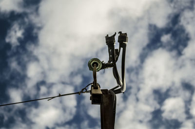 Low angle view of coin-operated binoculars against sky