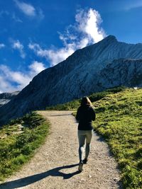 Rear view of man walking on mountain road