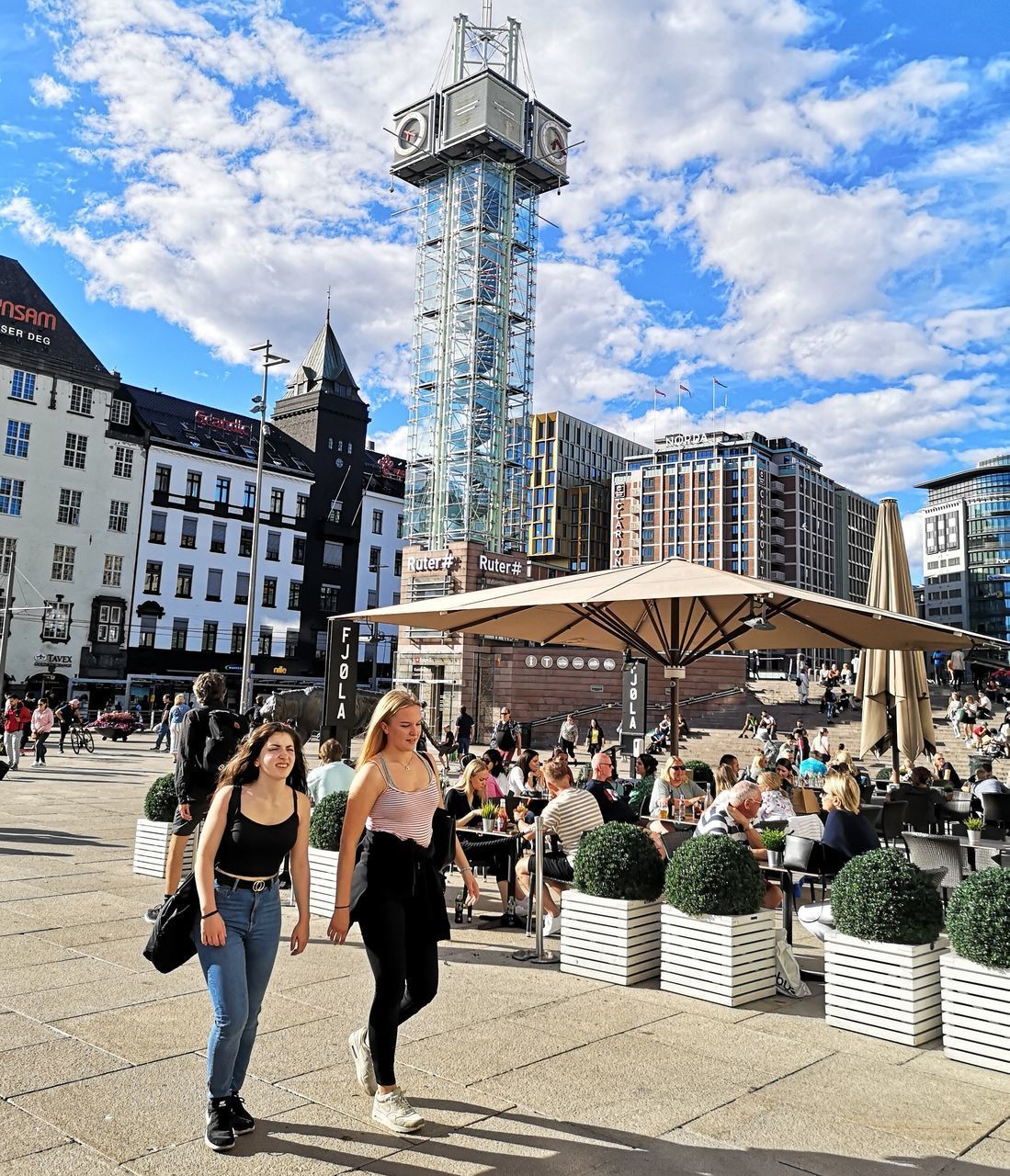 PEOPLE ON STREET BY BUILDINGS AGAINST SKY