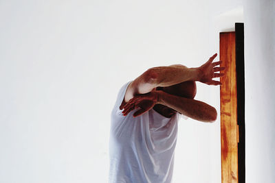 Scared man standing against white background