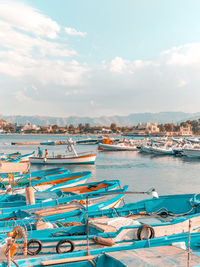Boats moored at harbor against sky