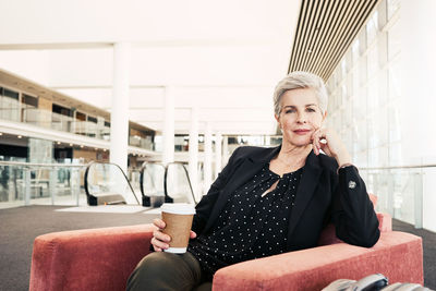 Portrait of woman sitting on chair at home