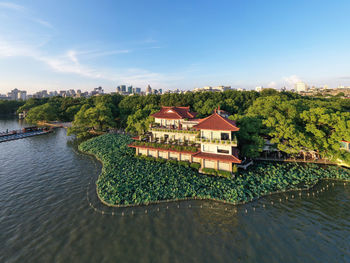 Buildings by river against sky