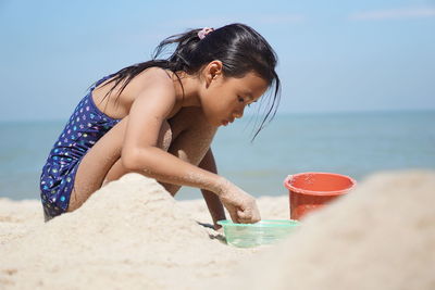 Boy on beach against sky