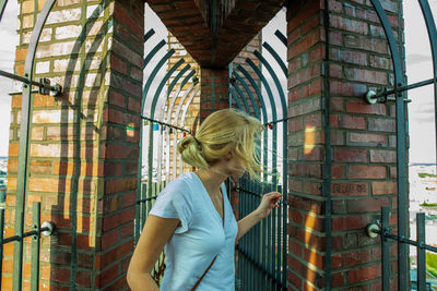 Young woman standing against the wall