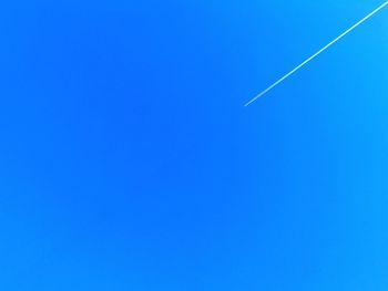 Low angle view of vapor trail against clear blue sky