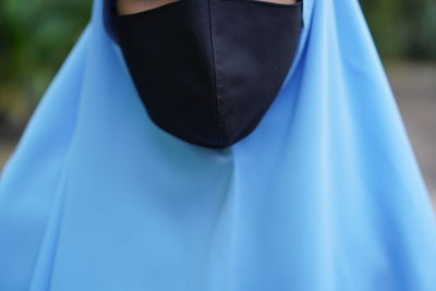 Close-up of person standing against blue background