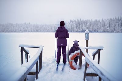 Rear view of woman in lake during winter