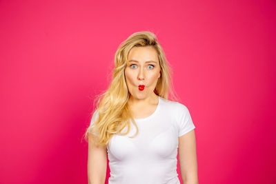 Portrait of woman against pink background