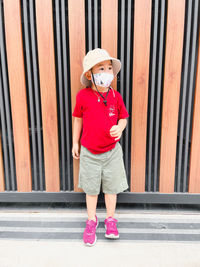 Portrait of boy standing against wall