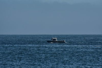 Boat sailing in sea against clear sky