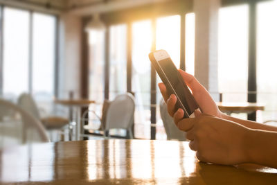 Person using smart phone on table at home