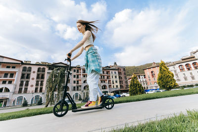 Teenage girl riding electric push scooter in park