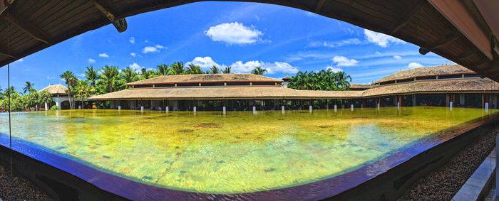 Panoramic shot of swimming pool by lake against sky