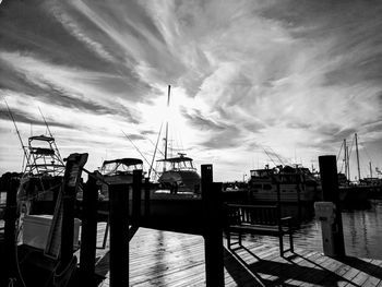 Boats moored at harbor against sky