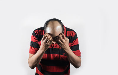 Portrait of young man standing against white background