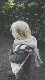 High angle view of woman walking on footpath by fence during winter