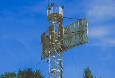 Low angle view of communications tower against blue sky