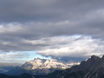 Scenic view of mountain range against cloudy sky