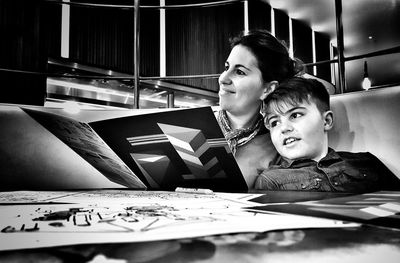 Cheerful mother and son sitting in restaurant