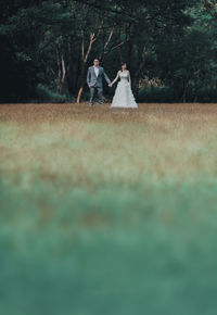 People standing on field against trees