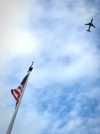 Low angle view of airplane flying against sky