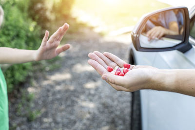 Daughter refusing food from father sitting in car 