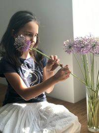 Girl holding flower at home