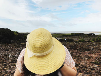 Midsection of woman wearing hat against sky