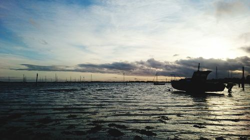 Boats in sea at sunset